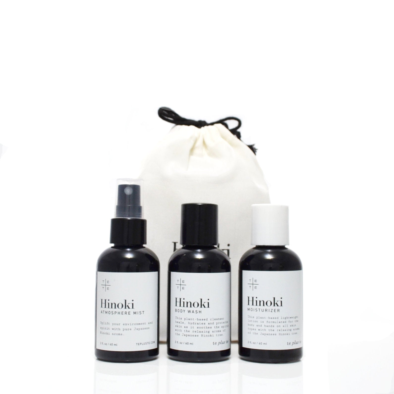three small body care products, hinoki standing in front of a bag. white background