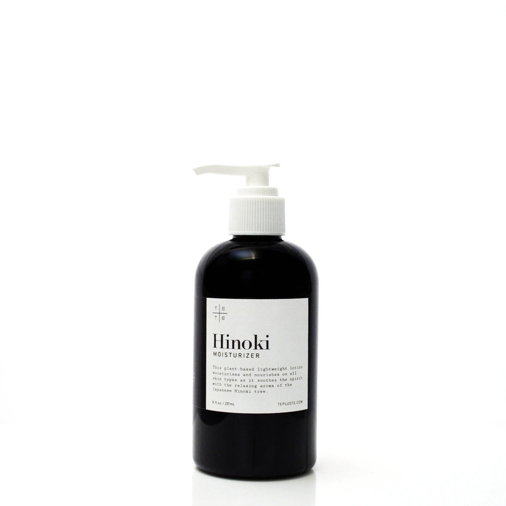 Black bottle of Hinoki moisturizer with a white label on a white background